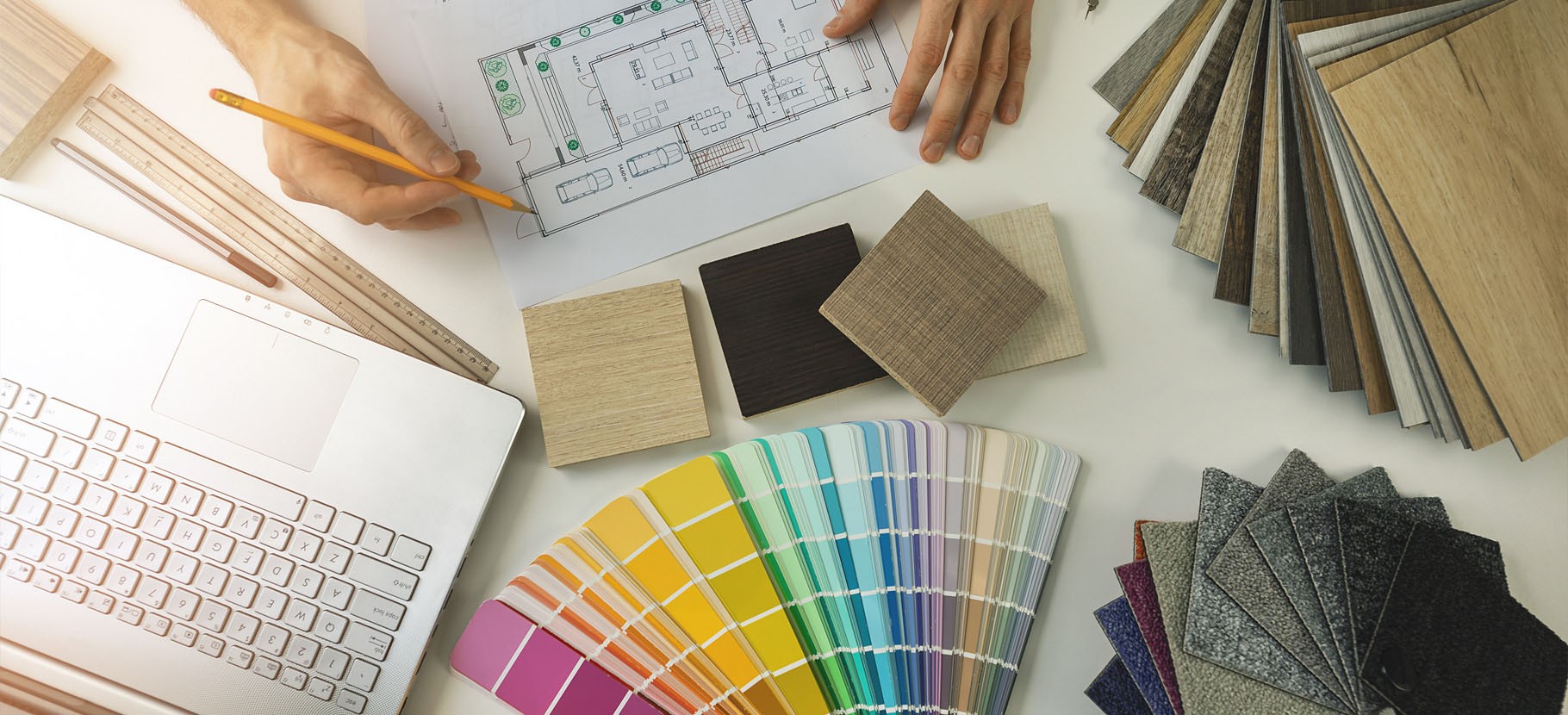 Arbeitstisch mit Laptop, Farbmustern und Bodenbelagsproben